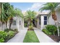 Inviting front entrance with lush landscaping and palm trees along the walkway at 8224 Simpson Falls Ct # 8224, Sarasota, FL 34243