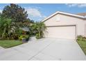 Charming home with a two-car garage, light stucco, and a walkway leading to the front door at 8224 Simpson Falls Ct # 8224, Sarasota, FL 34243