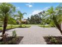 Long brick-paved driveway leads to the house, beautifully landscaped with palm trees at 1015 143Rd Ne St, Bradenton, FL 34212