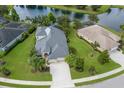 Aerial view of the property showing the manicured lawn, mature trees and proximity to a pond at 12015 Forest Park Cir, Bradenton, FL 34211