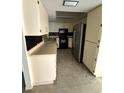 View of the kitchen with black backsplash, stainless steel refrigerator and tile flooring at 13017 Club Dr, Hudson, FL 34667