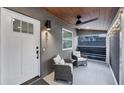 Relaxing front porch with seating, ceiling fan and string lights, and a white door with windows at 1919 Laurel St, Sarasota, FL 34236