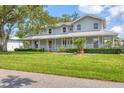 Inviting home showcasing a charming wrap-around porch and a well-maintained lawn at 2002 8Th W St, Palmetto, FL 34221
