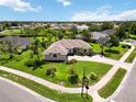 Expansive aerial view of a well-manicured lawn, lush landscaping, and a charming single-story home in a quiet neighborhood at 2199 Palm Ct, North Port, FL 34287