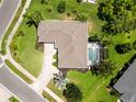 An aerial view of a private screened-in pool, surrounding landscaping, and a well maintained roof at 2199 Palm Ct, North Port, FL 34287