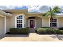 Close-up showcasing the front door, surrounding windows and attractive landscaping at 2199 Palm Ct, North Port, FL 34287