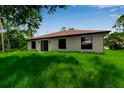 Expansive backyard of the home has a lush green lawn and beautiful tree surround at 23367 Mayville Ave, Punta Gorda, FL 33980