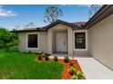 Inviting front entrance with meticulously maintained landscaping and white trim around the windows at 23367 Mayville Ave, Punta Gorda, FL 33980