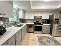 Well-lit kitchen featuring stainless steel appliances, a mosaic backsplash, and light wood flooring at 3272 Lake Bayshore Dr # 515, Bradenton, FL 34205