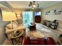Comfortable living room with neutral tones, stylish rug, a ceiling fan and a balcony with a view at 3272 Lake Bayshore Dr # 515, Bradenton, FL 34205