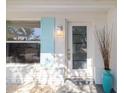 Inviting front entrance with a modern glass door, stylish light fixture, and a pop of color with a decorative vase at 3975 Coleridge Pl, Sarasota, FL 34241
