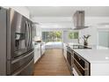 Modern kitchen with stainless steel appliances, white cabinets, and a view of the pool at 3975 Coleridge Pl, Sarasota, FL 34241