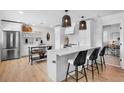 Bright kitchen featuring a quartz island, stainless appliances, and modern pendant lighting at 404 Bayshore Rd, Nokomis, FL 34275
