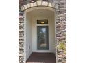Inviting front entrance with stone archway and decorative glass door at 4077 River Bank Way, Punta Gorda, FL 33980
