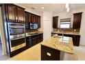Gourmet kitchen featuring stainless appliances, granite countertops, dark wood cabinets and tile backsplash at 4077 River Bank Way, Punta Gorda, FL 33980