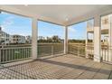 Spacious screened balcony with wood-look flooring offers views of the grassy area at 4318 Marina View Way, Cortez, FL 34215
