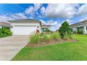 Attractive home featuring a two-car garage, well-kept lawn, and ornamental grasses at 4625 Canoe Creek Ave, Parrish, FL 34219