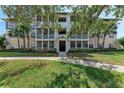 Multi-story condo building with screened-in porches, mature trees, and well-maintained landscaping at 4802 51St W St # 808, Bradenton, FL 34210