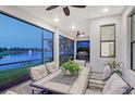 Covered patio with seating, overlooking the lake, ceiling fan, and outdoor dining set at 5187 Barnett Cir, Lakewood Ranch, FL 34211