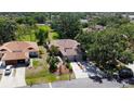 An aerial view of a well-maintained single-story home with lush landscaping and a spacious driveway at 5192 Cedar Hammock Ln, Sarasota, FL 34232