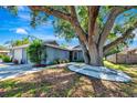 Charming single-story home boasting a large, mature tree and a well-maintained landscaped yard at 5192 Cedar Hammock Ln, Sarasota, FL 34232