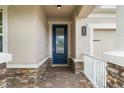 Inviting entryway with a stylish blue front door and brick-paved porch at 5240 Bentgrass Way, Bradenton, FL 34211