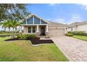 Charming single-Gathering home featuring a beautiful lawn, front porch, and two-car garage at 5240 Bentgrass Way, Bradenton, FL 34211