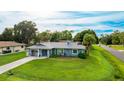 Beautiful single-story home with an attached garage and a well-maintained lawn on a sunny day at 5329 Ansonia Ter, North Port, FL 34287