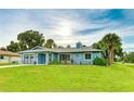 Charming single-story home with a well-manicured lawn, attached garage, and beautiful blue exterior paint at 5329 Ansonia Ter, North Port, FL 34287