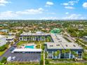 An aerial view showing the condo complex, pool, parking, landscaping, and the surrounding neighborhood at 5600 Beach Way Dr # 201, Sarasota, FL 34242