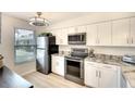 Modern kitchen with stainless steel appliances, sleek white cabinets, and plenty of natural light at 6024 28Th W St, Bradenton, FL 34207