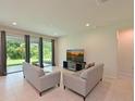 Inviting living room with sliding glass doors, neutral color scheme, and contemporary furnishings at 6204 Horse Mill Pl, Palmetto, FL 34221