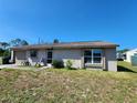 Single-story home with an attached garage, front door sitting area, and well-lit windows at 6405 Myrtlewood Rd, North Port, FL 34287