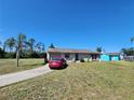Inviting single-story home with a spacious front yard, attached garage, and convenient driveway at 6405 Myrtlewood Rd, North Port, FL 34287
