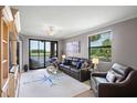 Living room featuring comfortable seating, a view of the pond, and nautical-themed decor at 6515 Grand Estuary Trl # 208, Bradenton, FL 34212