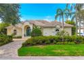 Charming single-story home with a tile roof, well-maintained landscaping, and a stone paver driveway, offering curb appeal at 7214 Marlow Pl, University Park, FL 34201