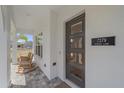 View of front entrance with rocking chairs, modern door with windows and address at 7279 Kodiak Ln, Sarasota, FL 34240