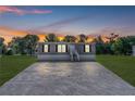 Charming home with a gravel driveway, well maintained lawn, and freshly painted siding at dusk at 8426 Sweden Blvd, Punta Gorda, FL 33982