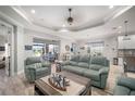 Open-concept living room with tile floors, coastal decor, and view into dining room and kitchen at 10423 Morning Marsh Ln, Parrish, FL 34219