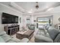 Bright living room featuring tile floors, leather furniture, fireplace, and view of pool at 10423 Morning Marsh Ln, Parrish, FL 34219