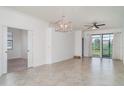 Open concept living space with tile floors, modern lighting, and sliding glass doors leading to outdoor area at 12515 Garibaldi Ln, Venice, FL 34293