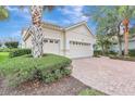 Home exterior with a three-car garage, landscaped front yard and brick paver driveway at 12710 Stone Ridge Pl, Lakewood Ranch, FL 34202