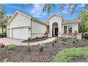 Beautifully landscaped front yard leading to the home's entrance, complemented by a three-car garage at 12710 Stone Ridge Pl, Lakewood Ranch, FL 34202