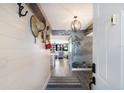 Inviting hallway with wood flooring, decorative wall hangings, and stylish lighting fixture at 1445 Gulf Of Mexico Dr # 203, Longboat Key, FL 34228