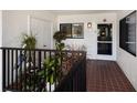 Welcoming condo hallway with tiled floor, decorated with plants, and natural light coming through the windows at 1445 Gulf Of Mexico Dr # 203, Longboat Key, FL 34228