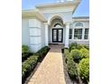 Inviting front entrance with brick walkway, decorative columns, and lush landscaping enhancing the home's curb appeal at 1539 Ormond Ter, Parrish, FL 34219