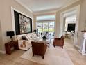 Elegant living room featuring neutral tones, stylish decor, and sliding glass doors opening to the pool area at 1539 Ormond Ter, Parrish, FL 34219