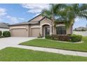 Well-maintained single-story home featuring a three-car garage, lush lawn, and attractive shrubbery at 18620 Cortes Creek Blvd, Spring Hill, FL 34610