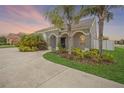 Home exterior features a covered entry way, lush landscaping, and a concrete driveway at 1905 Via Napoli St, Plant City, FL 33566