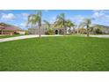 Wide shot of house showcasing lush lawn, palm trees, and a three-car garage at 1905 Via Napoli St, Plant City, FL 33566
